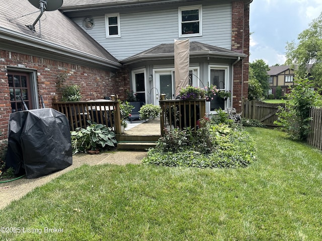 back of house with a wooden deck and a lawn