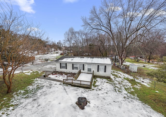 snow covered back of property featuring a wooden deck