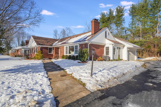 view of front of home with a garage and central air condition unit