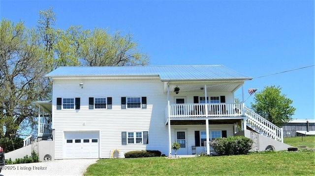 view of front of property featuring a garage, a front yard, and a balcony