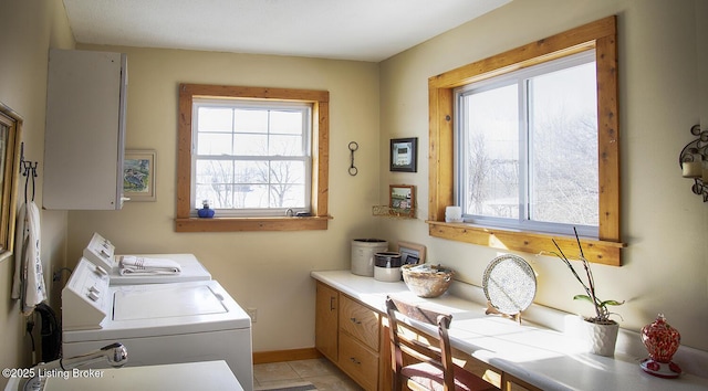 laundry room with cabinets, washer and clothes dryer, and plenty of natural light