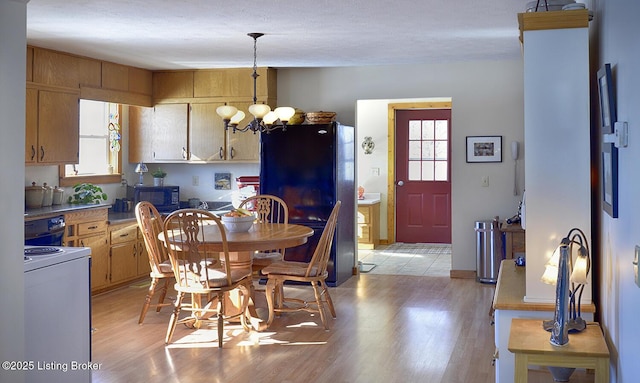 dining room with light wood-type flooring and an inviting chandelier