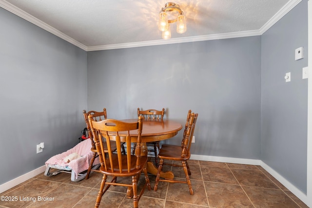 dining space with dark tile patterned floors, ornamental molding, and a textured ceiling