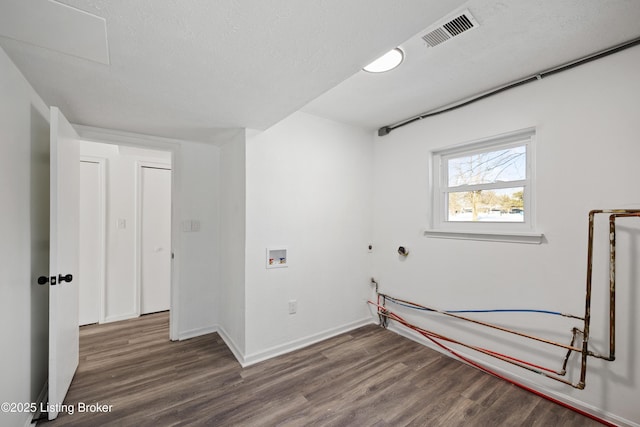 washroom with washer hookup, dark wood-type flooring, and a textured ceiling