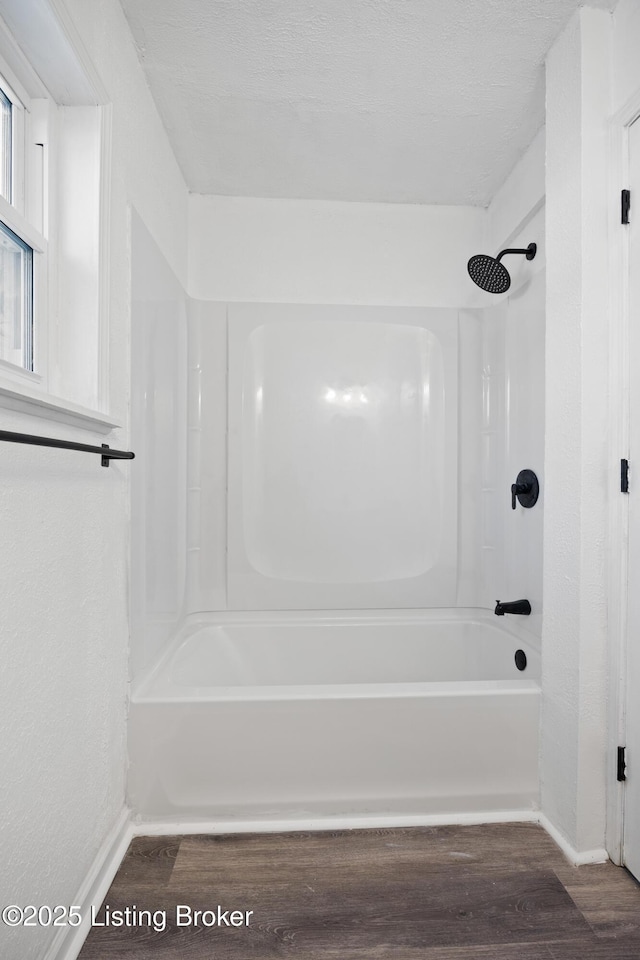 bathroom with shower / washtub combination and hardwood / wood-style flooring