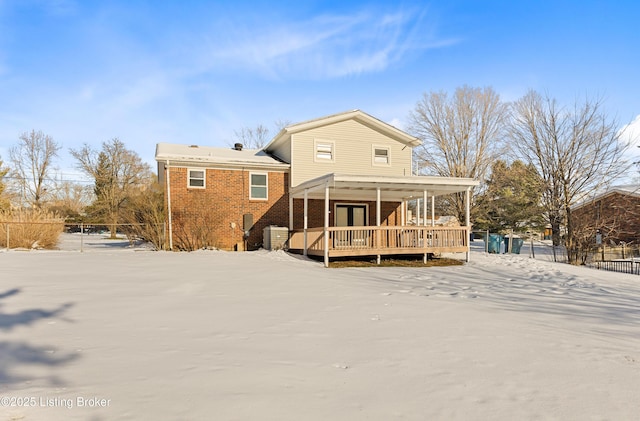 snow covered rear of property featuring covered porch