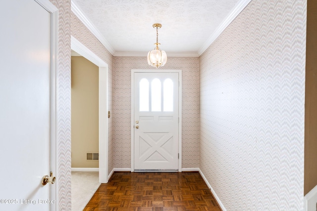 doorway with dark parquet flooring, a textured ceiling, and ornamental molding