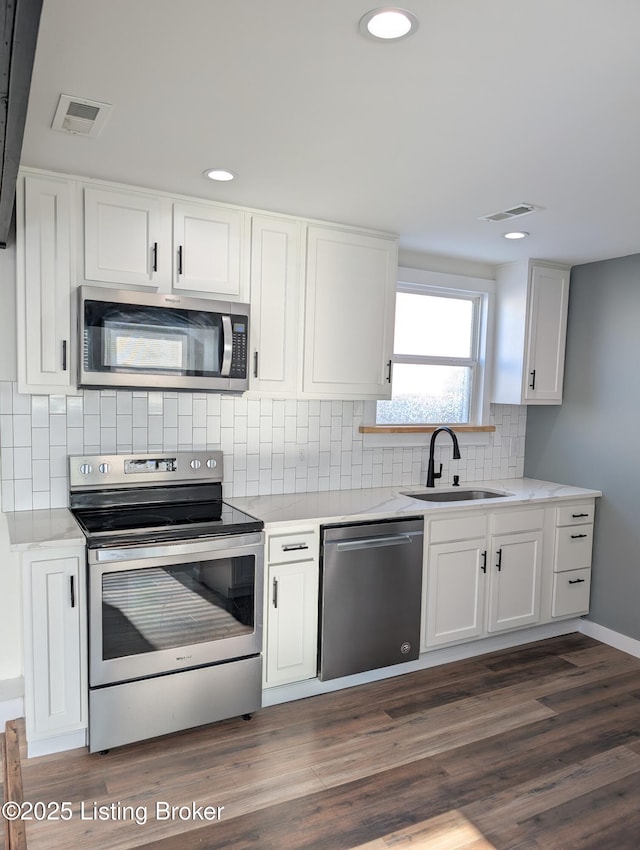 kitchen featuring sink, stainless steel appliances, white cabinets, and dark hardwood / wood-style floors