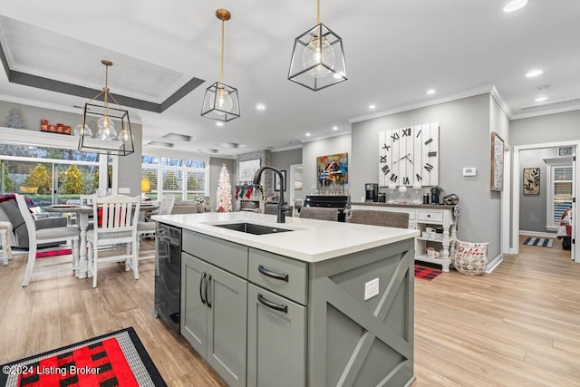 kitchen with sink, hanging light fixtures, an island with sink, and beverage cooler