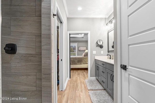 bathroom with vanity, ornamental molding, and hardwood / wood-style flooring