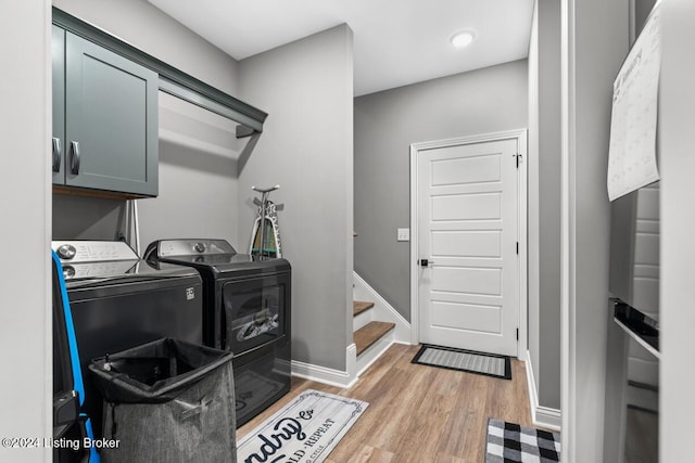 laundry room featuring cabinets, separate washer and dryer, and light hardwood / wood-style floors