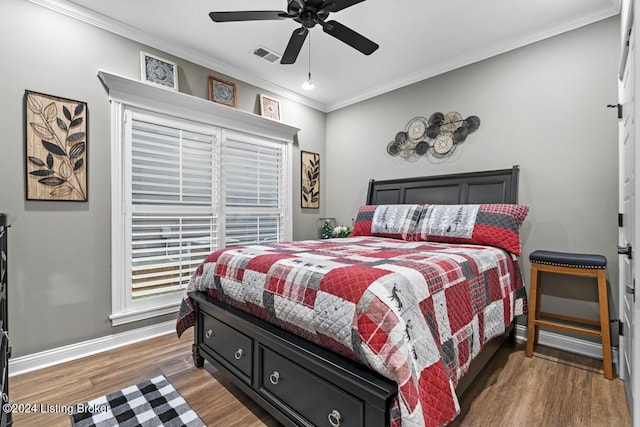 bedroom featuring ceiling fan, ornamental molding, and dark hardwood / wood-style floors