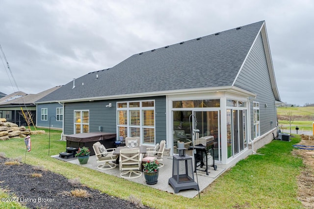 rear view of house featuring central AC unit, a hot tub, a yard, and a patio area