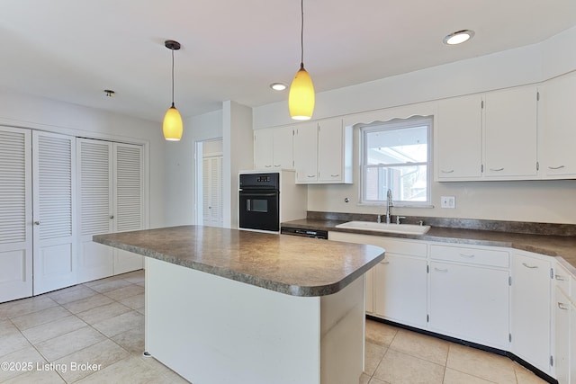 kitchen with white cabinets, sink, oven, and pendant lighting