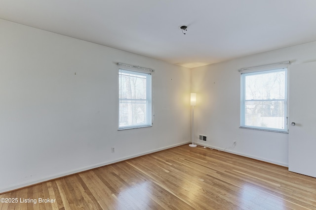 empty room with light hardwood / wood-style flooring and a healthy amount of sunlight