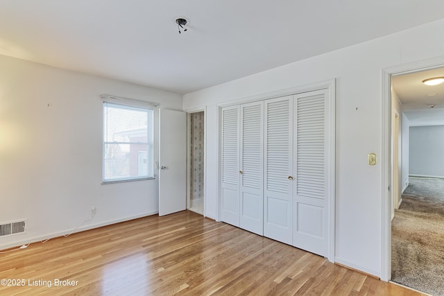 unfurnished bedroom with a closet and hardwood / wood-style floors