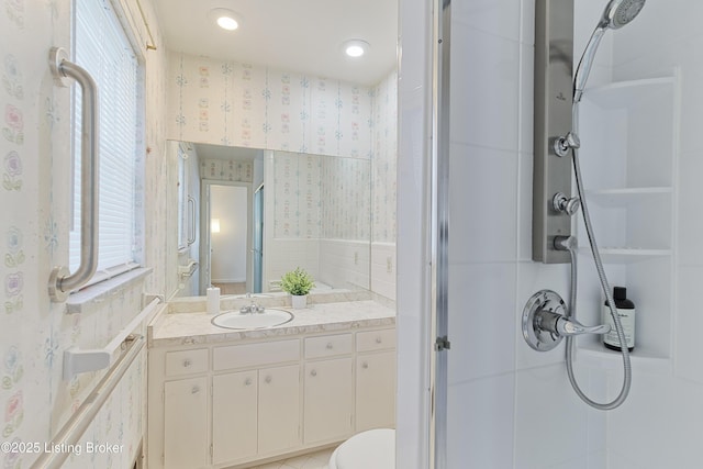 bathroom with vanity, toilet, plenty of natural light, and a shower with door