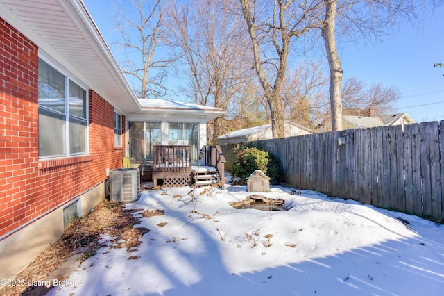 snowy yard with cooling unit and a deck