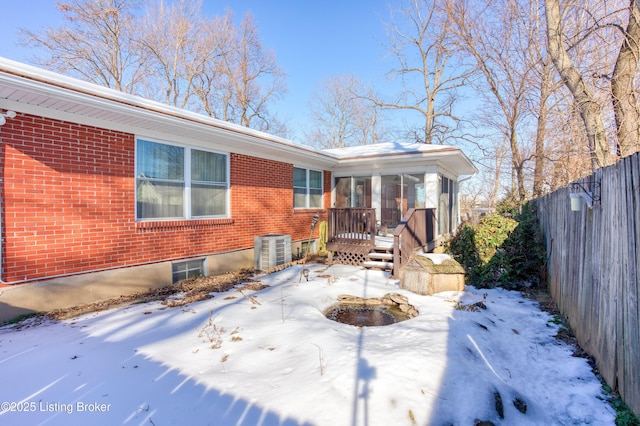 exterior space with a deck, central air condition unit, and a sunroom