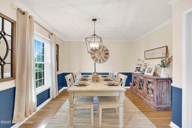 dining room featuring light hardwood / wood-style floors, ornamental molding, and a chandelier