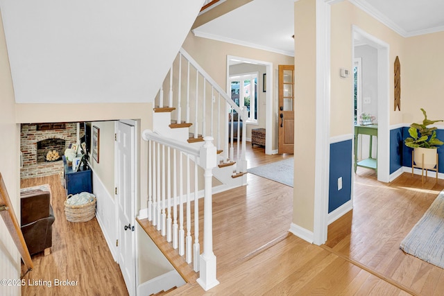 stairs with crown molding and wood-type flooring