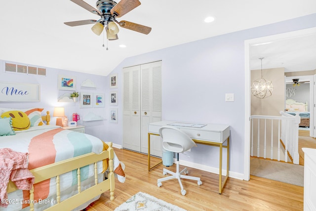 bedroom featuring light hardwood / wood-style flooring, a closet, vaulted ceiling, and ceiling fan with notable chandelier