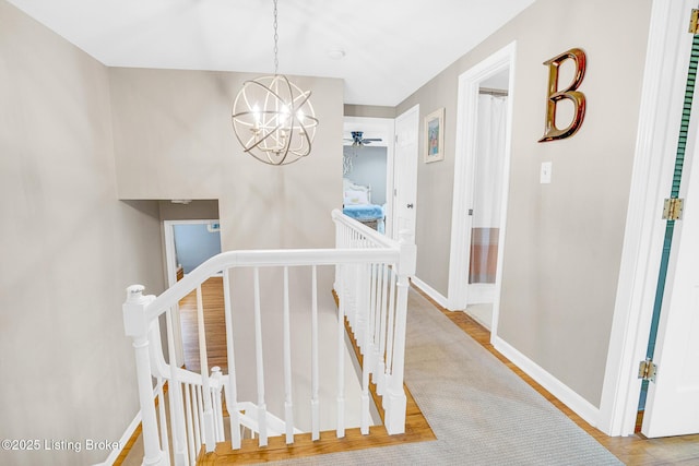 hallway featuring wood-type flooring and a chandelier