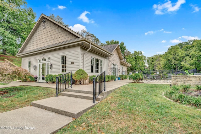 view of home's exterior with french doors, a yard, and a patio