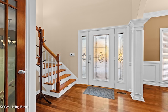 entryway with decorative columns, hardwood / wood-style flooring, and crown molding