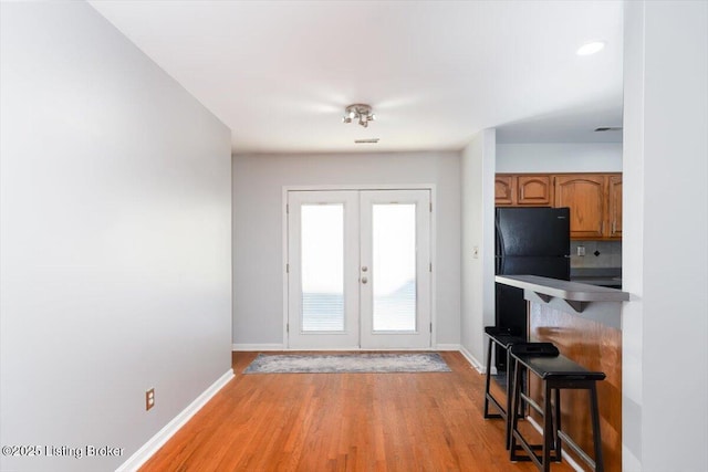 entryway with french doors and light hardwood / wood-style floors