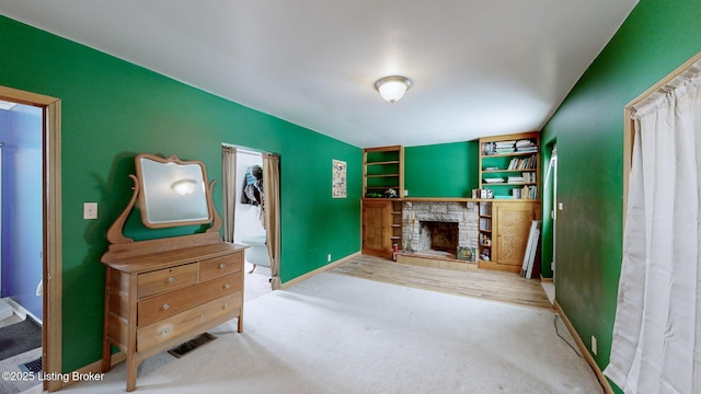 interior space with ensuite bathroom, a fireplace, and carpet flooring