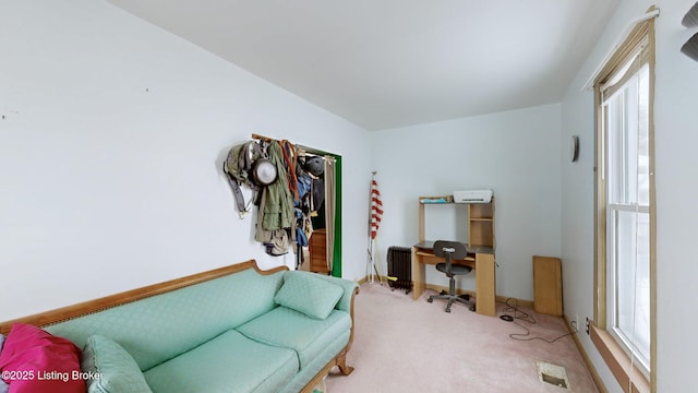 sitting room featuring a wealth of natural light, radiator, and carpet flooring