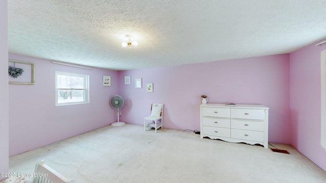 unfurnished bedroom featuring light colored carpet and a textured ceiling