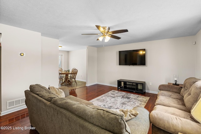 living room with dark wood-type flooring and ceiling fan