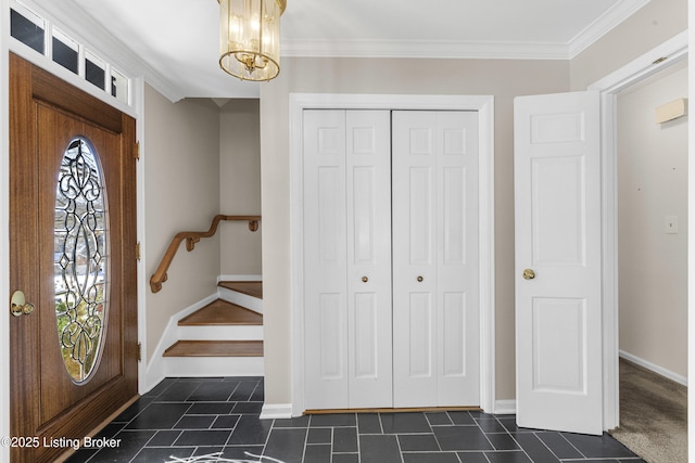 foyer with crown molding and an inviting chandelier