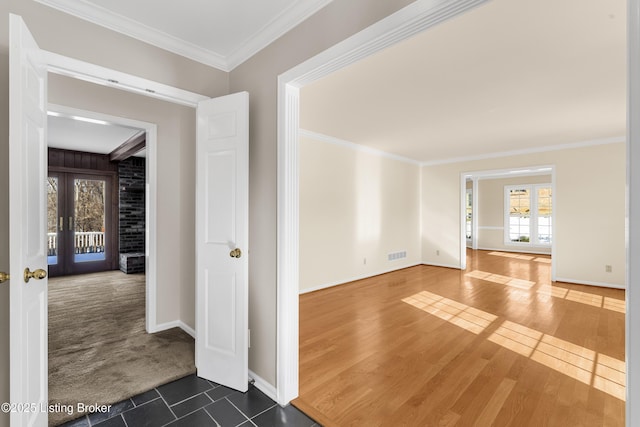 spare room featuring dark tile patterned floors, french doors, and ornamental molding