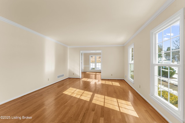 unfurnished living room with plenty of natural light, ornamental molding, and light hardwood / wood-style floors