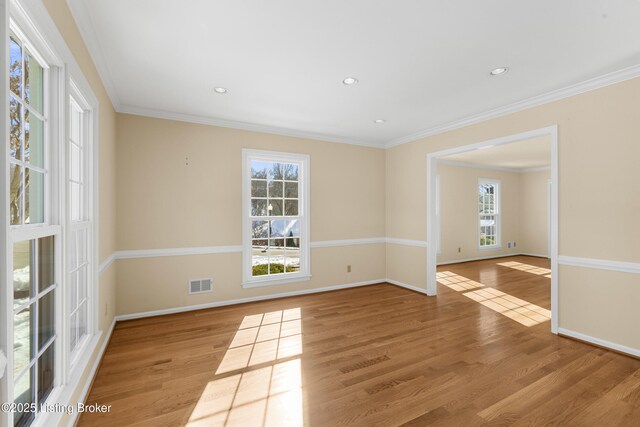 empty room with ornamental molding and light wood-type flooring