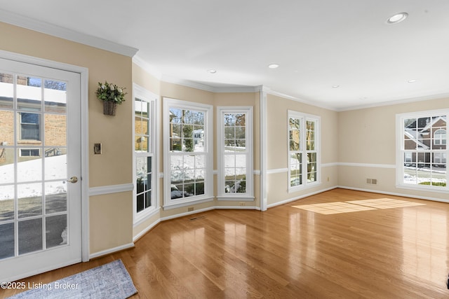 doorway with crown molding and light wood-type flooring