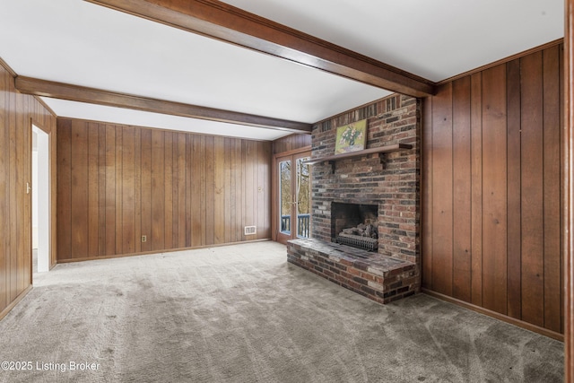 unfurnished living room with a fireplace, beamed ceiling, and wooden walls