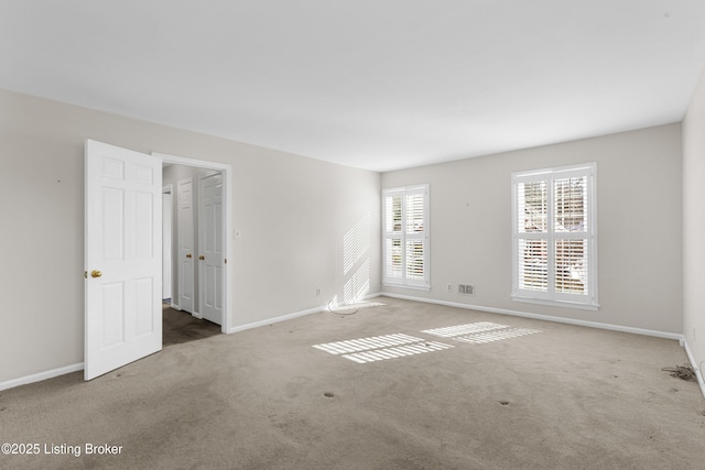 unfurnished room featuring light carpet