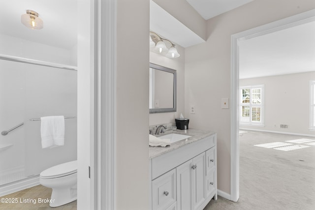 bathroom featuring a shower with door, toilet, and vanity