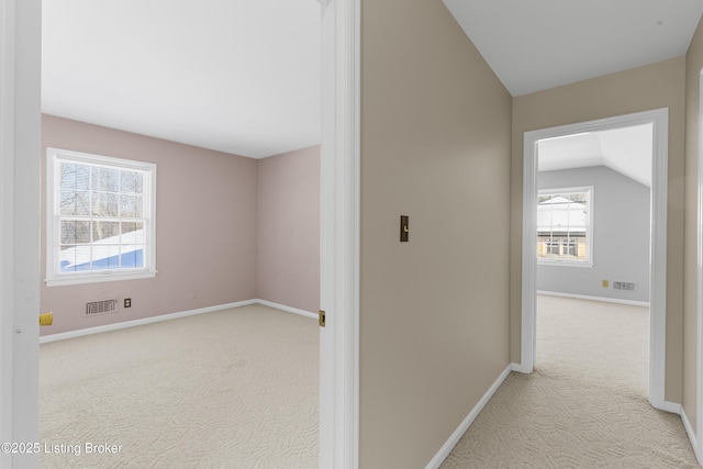 hall with light carpet and lofted ceiling