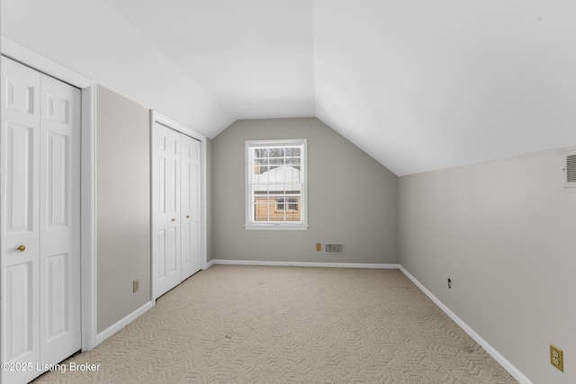 bonus room featuring vaulted ceiling and light colored carpet