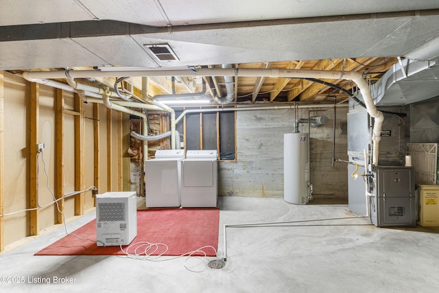 basement with washer and dryer, heating unit, and gas water heater