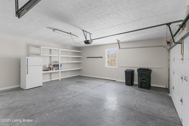 garage featuring white fridge and a garage door opener