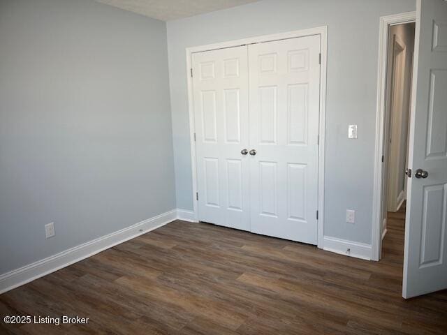 unfurnished bedroom with a closet and dark hardwood / wood-style flooring