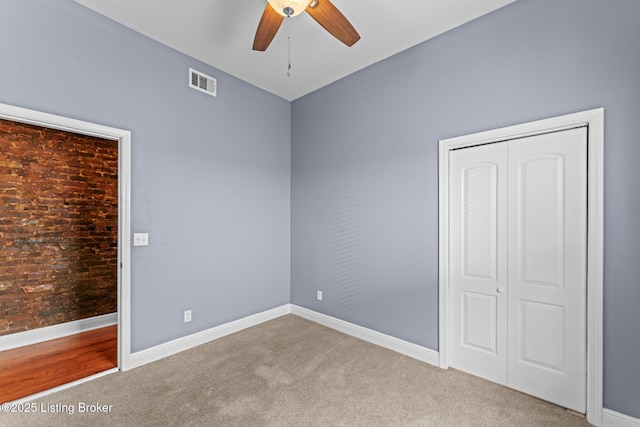 unfurnished bedroom featuring ceiling fan, a closet, and light carpet