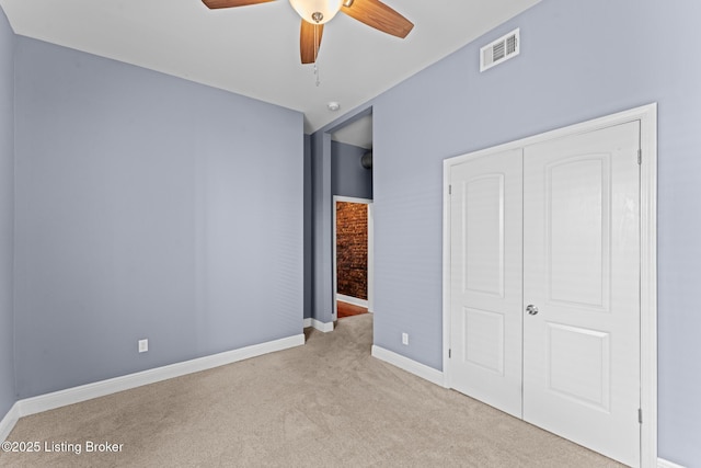 unfurnished bedroom with light colored carpet, ceiling fan, and a closet