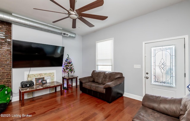 living room with ceiling fan, wood-type flooring, and plenty of natural light